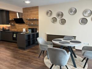 una cucina e una sala da pranzo con tavolo e sedie di Esterhazy Apartman a Galanta