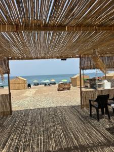 a view of a beach with a bench and umbrellas at Chalets MB in Tarîfa