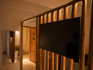 a flat screen tv hanging on a wooden rail at Villa Vinci Flat in São Miguel do Gostoso