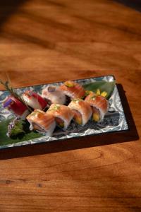 a plate of sushi on top of a wooden table at Masana Algarve, Destination by Hyatt in Albufeira