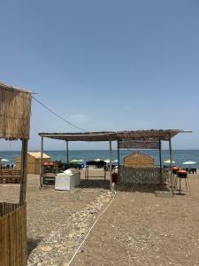 a pavilion on the beach with the ocean in the background at Chalets MB in Tarîfa