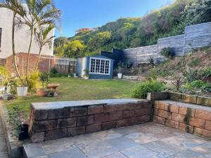 a backyard with a brick retaining wall and a house at 303 Kusweg Tergniet in Tergniet