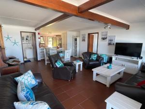a living room with leather furniture and a flat screen tv at 303 Kusweg Tergniet in Tergniet