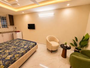 a bedroom with a bed and a chair and a tv at Motorway Majesty Heights - Near Islamabad International Airport and Motorway in Islamabad +4 photos