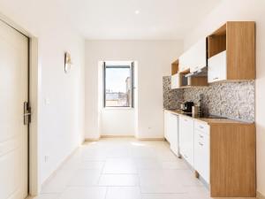 a kitchen with white cabinets and a large window at Wanderlust Experience Loggiato del duca in Bitonto