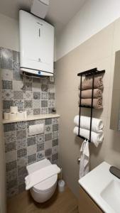 a bathroom with a toilet and a sink and towels at Apartmani Alexa 2 in Brist +33 photos