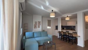 a living room with a blue couch and a table at Apartmani Alexa 2 in Brist