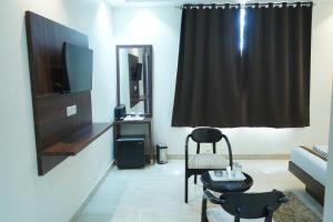a living room with a chair and a mirror at Hotel High Residency in New Delhi