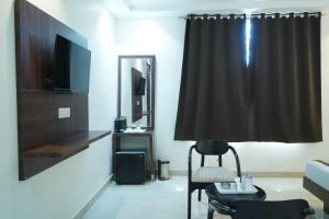 a living room with a black curtain and a chair at Hotel High Residency in New Delhi