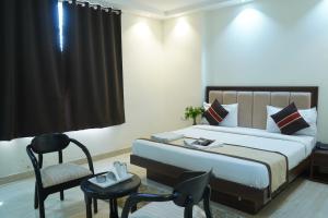 a hotel room with a bed and a chair at Hotel High Residency in New Delhi