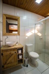 a bathroom with a toilet and a sink and a shower at Pousada Costaneira in Cambará +50 photos
