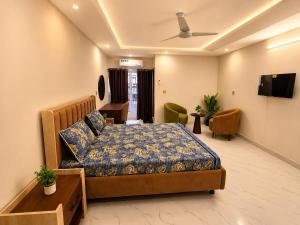 a bedroom with a bed and a tv in it at Motorway Majesty Heights - Near Islamabad International Airport and Motorway in Islamabad