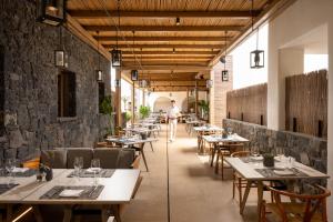 a man walking through a restaurant with tables at Radisson Blu Zaffron Resort, Santorini in Kamari