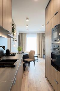 a kitchen with a counter and a living room at Apartament Stara Fabryka 42 in Włocławek