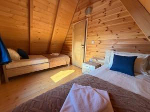 a bedroom with a bed in a wooden cabin at Durmitor Den in Žabljak