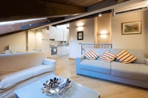a living room with two couches and a kitchen at BolognaRoomscom - Santo Stefano Apartments in Bologna