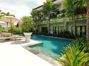 a swimming pool in front of a building at Indah Homestay in Seminyak