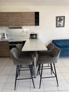 a kitchen with a table and four chairs at l'arc logement in Strasbourg +3 photos