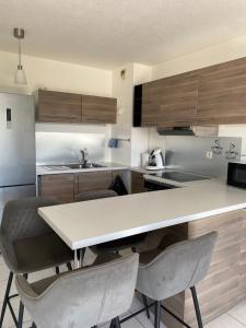a kitchen with a table and some chairs in it at l'arc logement in Strasbourg