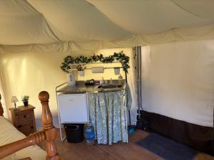 a bedroom with a tent with a sink in it at Old Dairy Farm Glamping in Emsworth