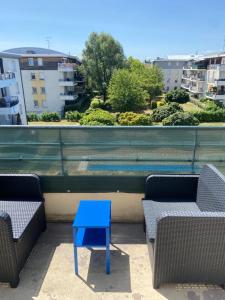 a blue table sitting between two chairs on a balcony at l'arc logement in Strasbourg