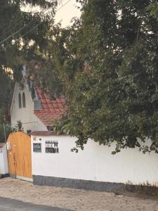 a white building with a gate and a church at Fonfa Liget in Sénye