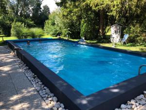 a swimming pool with blue water in a yard at Fonfa Liget in Sénye