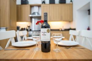 a bottle of wine sitting on a table with two glasses at Picture Cottage in Solva +19 photos