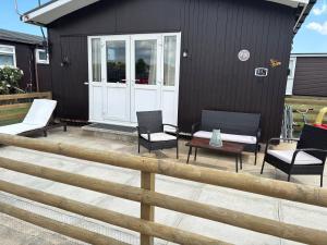 a patio with chairs and a table and a house at Retreat to the Chalet in Withernsea