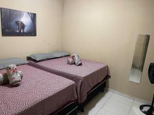 two twin beds in a bedroom with purple sheets at Casa grande in Garanhuns +20 photos
