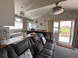 a living room with a couch and a table at Retreat to the Chalet in Withernsea