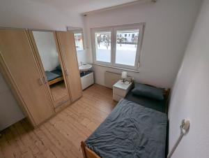 a small room with a bed and a sink at Härtsfeldwohnungen in Neresheim