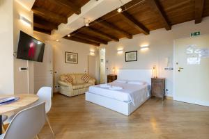 a bedroom with a bed and a couch and a tv at BolognaRoomscom - Santo Stefano Apartments in Bologna