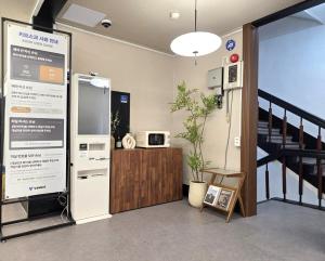 a room with a staircase with a refrigerator and a table at 페블스테이 남포점 in Busan