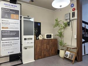 a kitchen with a refrigerator and a microwave at 페블스테이 남포점 in Busan