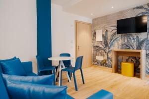 a living room with a table and chairs and a tv at lillil - Popping Holiday in Riva del Garda