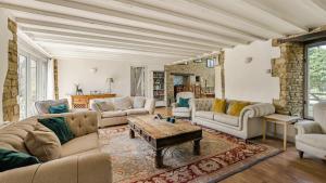 a living room with couches and a table at Butts Farm in Cirencester