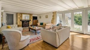 a living room with couches and a fireplace at Butts Farm in Cirencester +21 photos