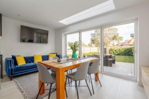 a dining room with a table and chairs and a couch at The Laurels by Grandeur Property in Poole