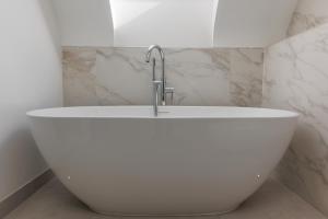 a white bath tub with a faucet in a bathroom at The Laurels by Grandeur Property in Poole +82 photos