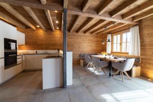a kitchen and dining room with a table and chairs at Chalet Brisi - Luxury & Bergblick in Wildhaus +22 photos