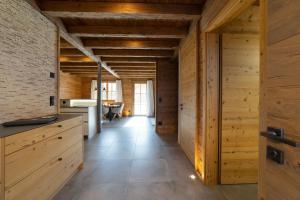 a kitchen with wooden walls and a long hallway at Chalet Brisi - Luxury & Bergblick in Wildhaus