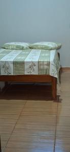 two boxes sitting on a bed on a wooden floor at Home Comfort in Poconé