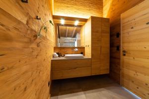 a bathroom with a sink in a wooden wall at Chalet Brisi - Luxury & Bergblick in Wildhaus