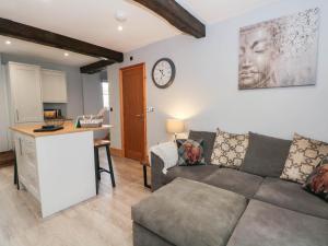 a living room with a couch and a desk and a clock at Barn 2 in Sandbach