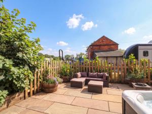 a backyard patio with a couch and a fence at Barn 2 in Sandbach