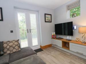 a living room with a couch and a flat screen tv at Barn 2 in Sandbach