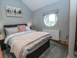 a bedroom with a bed and a window at Barn 2 in Sandbach