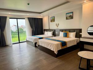 a hotel room with two beds and a balcony at Family Transit Hotel in Thach Loi +114 photos