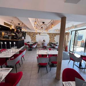 a dining room with tables and red chairs at Hotêl - Restaurant Le Bon Duc in Les Billaux
